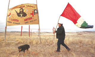 im Lame Woman put up a flag and American Indian Movement banner