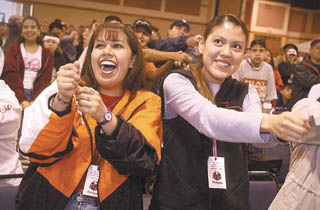 Vania White, left, and Lisa Pretty on Top participate with the rest of the crowd using hand signals to sing a song Tuesday at the Northwest Indian Youth Conference in Billings.