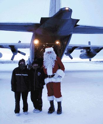 Arctic Village children greet Santa as he arrived via a C-130 Hercules Tuesday. The 517th Airlift Squadron has been bringing food, supplies and gifts to the remote village for 34 years. (Photo by 1st Lt. Johnny Rea) 