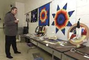 Bryan Brewer, director of the Lakota Nation Invitational and principal of Pine Ridge High School, looks over some of the student-made arts and crafts in the LNI Art Show. (Steve McEnroe/Journal staff) 