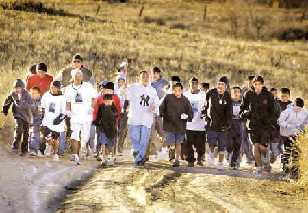 Runners pound out the final yards of their 400-mile relay run from Fort Robinson, Neb., to Busby on the Northern Cheyenne Reservation Thursday. The annual Breakout Memorial Run marks the journey made 124 years ago by ancestors who broke out of captivity at the U.S. Army fort and their historic flight to return to their homeland.