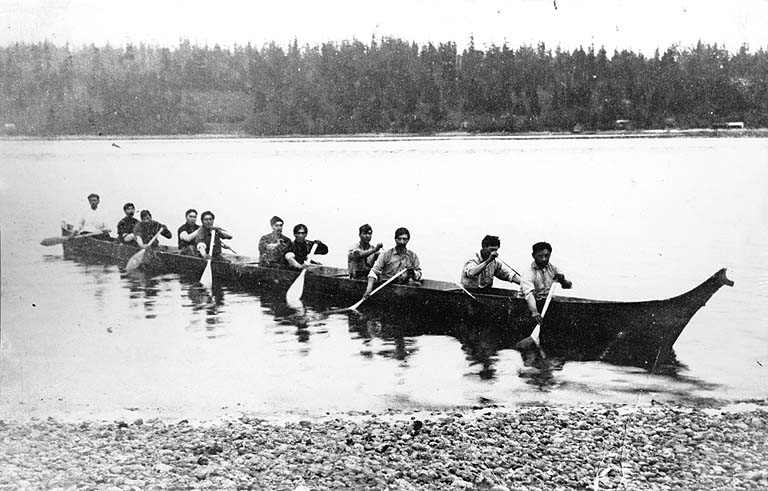 In 1909, Jack Adams, a member of the Suquamish Tribe, built a canoe for an Indian canoe race at Seattle's Alaska-Yukon-Pacific Exposition. Adams built the vessel from a single 48-foot log. On September 6, the canoes raced to the finish line at the foot of the fair's Pay Streak, in Portage Bay. In this photo, Adams and ten other men paddle the canoe on Portage Bay.