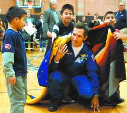 Astronaut shares his experiences - After a presentation to students at Chief Leschi Friday, astronaut John Bennett Herrington is wrapped in an American Indian storyteller's blanket. 