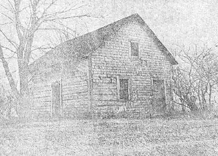Mrs. Robert's First Home, a well built log house, shingled. The house is still standing and the original hand-shaved shingles are on its walls.