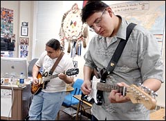 Paul Plume, 17, (right) plays guitar with his teacher, Roger White Eyes, at Red Cloud Indian School. Plume has been inspired by White Eyes and plans to attend college and become a teacher. 