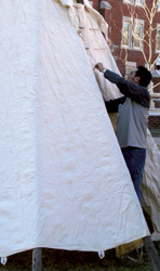 A group of students build a tipi beside Ellison Hall on Monday.