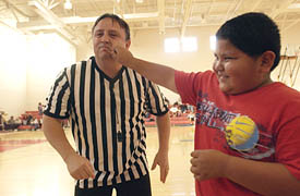 TWEAKING THE REF is not a foul during halftime of the Paiute Classic Basketball Tournament in Cedar City, which follows the tribe's Restoration Day each April. Getting cheeky is David Bushhead; the referee is Robert Langston. (Al Hartmann/The Salt Lake Tribune) 