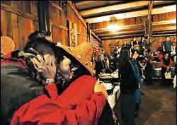 LaMetta LaClair, in traditional cedar hat, kisses her nephew Jim Smith as he enters the longhouse for the feast and potlatch at the Skokomish Indian Reservation. About 200 came from around the state for the feast. LaClair brought a pot of homemade geoduck chowder made with her grandmother's recipe. 