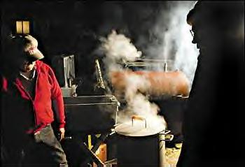 Tom Gouley, left, and José Vigil tend the steaming pot of clams just outside the Skokomish smokehouse, or longhouse. Cooking continues outside and in the kitchen right up to the beginning of the Skokomish Indian tribe's feast and potlatch, in which gifts were given. 