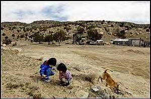 Sierra Chopito plays with her cousin, Sydnee Jazzie, 2, as they search for newly emerging wildflowers in the spring soil of their family's land on the Navajo reservation. Sierra, who lives for the most part about a 20-minute drive away in Gallup, N.M., spends most of her weekends and holidays on the family's land where her chei (great-grandfather) herds sheep and makes his coffee on a pot-bellied stove that heats the house. Sierra's mom, Ethel Ellison, say Sierra and Sydnee are inseparable.