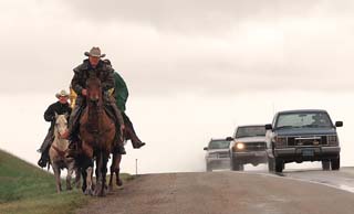 Cheyenne riders mix with traffic on Highway 212 near the Little Bighorn Battlefield National Monument.