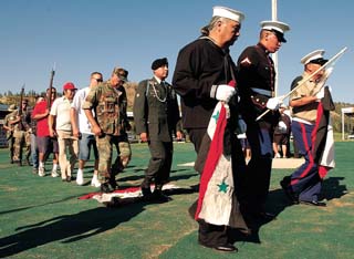 U.S. Marine Lomar Wandering Medicine, center, is flanked by uncles Isadore White Wolf, left, and Hugh Club Foot as the men dance across an Iraqi flag during a Cheyenne Victory Dance celebration in Lame Deer Wednesday afternoon. Wandering Medicine was being honored by his friends, family and veterans for his service in Iraq and carries a coup stick during the dance. His uncles carry flags that used to fly on Saddam’s limousines.
