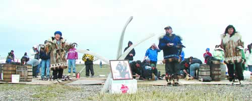 THANKING, SHARING, GRIEVING—Whaling captains Vera Frankson (left), Rex and Ramona Rock share muktuk with the village and put up a memorial picture of Josie Frankson.