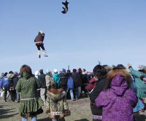 FLYING RUFFS—A young mother tossing fur into the crowd - only elderly ladies were allowed to catch the goodies.
