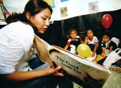 Navajo Prep senior Marian Goodluck reads to a first grade class from Aneth Community School in Aneth, Utah, Friday at the 92nd Annual Northern Navajo Fair in Shiprock. Goodluck and other Navajo American Literature classmates read from books by Native artists as part of the Dine Naaltsoos Adayiilaaigii Yinilta, or Read Navajo Author. (Photo special to the Times - Donovan Quintero) 