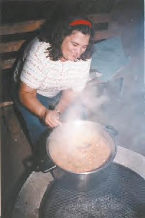 Serving up a heaping ladle of caribou stew is Elaine Tambour, the coordinator of the family cookbook containing traditional recipes from Southern Great Slave Lake. The book will be written in South Slavey and English, one of very few publications in this northern Indian dialect. (Photo by Matt Ross)