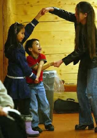 AGELESS APPEAL--Chanel Simon, left, dances Friday afternoon with her brother Randy, middle, and their cousin, Candice Carlo, during the 21st annual Athabascan Fiddlers Festival in the David Salmon Tribal Hall. The music performed during the festival appeals to those both young and old. Sam Harrel/News-Miner