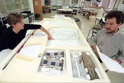 Smithsonian Institution technician Betsy Bruemmer, left, and anthropologist Chuck Smythe examine Sioux artifacts in Washington, D.C. that were being sent to Wounded Knee, S.D., for repatriation. - photo by Pete Souze - Chicago Tribune, 1998