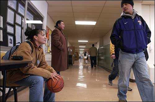 Haskell Indian Nations University students Honey Round Face, left, chats with her brother, Theodore Round Face, as he passes by on his way to class. Standing second from left, is Kemo Sauba, from Grand Rapids, Mich. The Round Faces, from Pryor, Mont., spoke Friday in the hallway of Haskell''s Sequoyah Hall. Honey carried a ball with her for good luck before Friday's women's basketball game.  - Thad Allender/Journal-World Photo