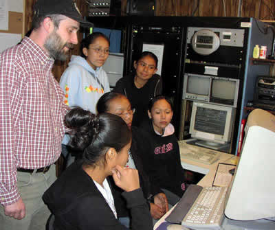 Teacher John Hall looks on as from left to right, Delphina Stanley, Denisha Gilmore, Betisha Reese, Desiray Begay and Kendra Clitso look for constellations on the high powered telescope receiving computer. (Photo Courtesy Honeywell Hometown Solutions)